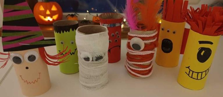 Bunte, selbst gebastelte Halloween-Figuren aus Toilettenpapierrollen mit Gesichtern und Dekorationen