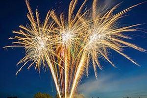 Mehrere goldene Feuerwerksfontänen leuchten am nächtlichen Himmel
