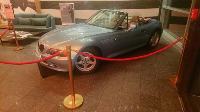 Silbernes Cabrio in einer Ausstellung hinter rotem Absperrseil