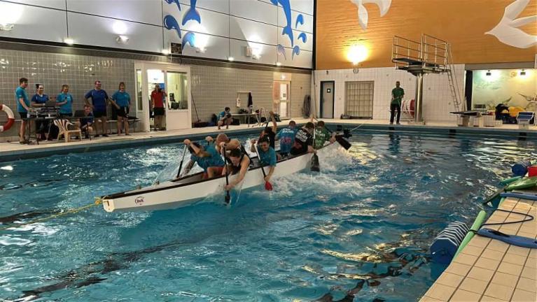 Menschen trainieren in einem Schwimmbecken mit einem Drachenboot