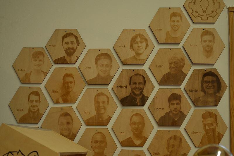 Die Crew in einer selbst entworfenen Waben-Collage aus Holz.